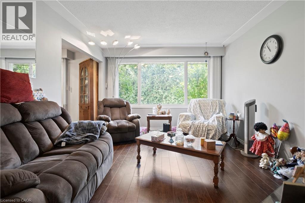 Living area featuring wood-finish flooring, a large window, light gray walls, and recessed lighting - 179 Vancouver Street, London, ON - Indoor Photo Showing Living Room