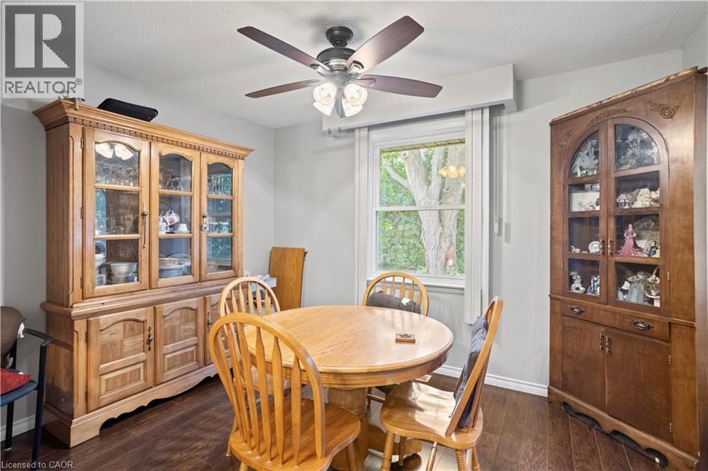 Dining area with dark wood-finish flooring, light grey wall paint, and a white window frame - 179 Vancouver Street, London, ON - Indoor Photo Showing Dining Room
