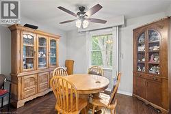 Dining area with dark wood-finish flooring, light grey wall paint, and a white window frame -