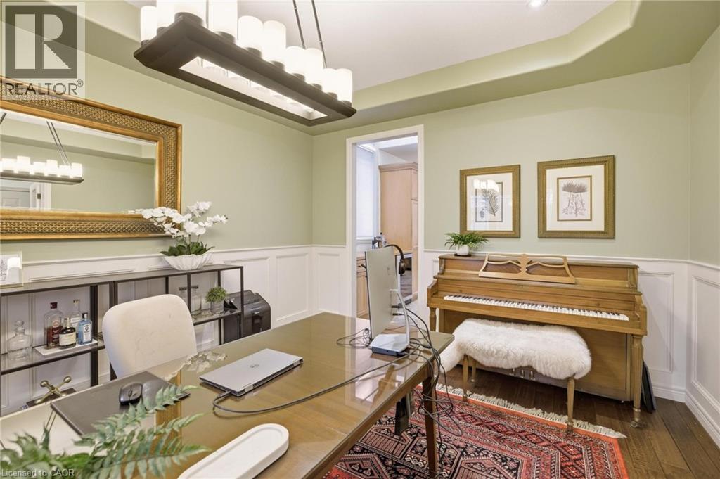 Spacious room featuring light green walls, wainscoting, recessed lighting, and a prominent rectangular chandelier - 129 Magnificent Way, Binbrook, ON - Indoor