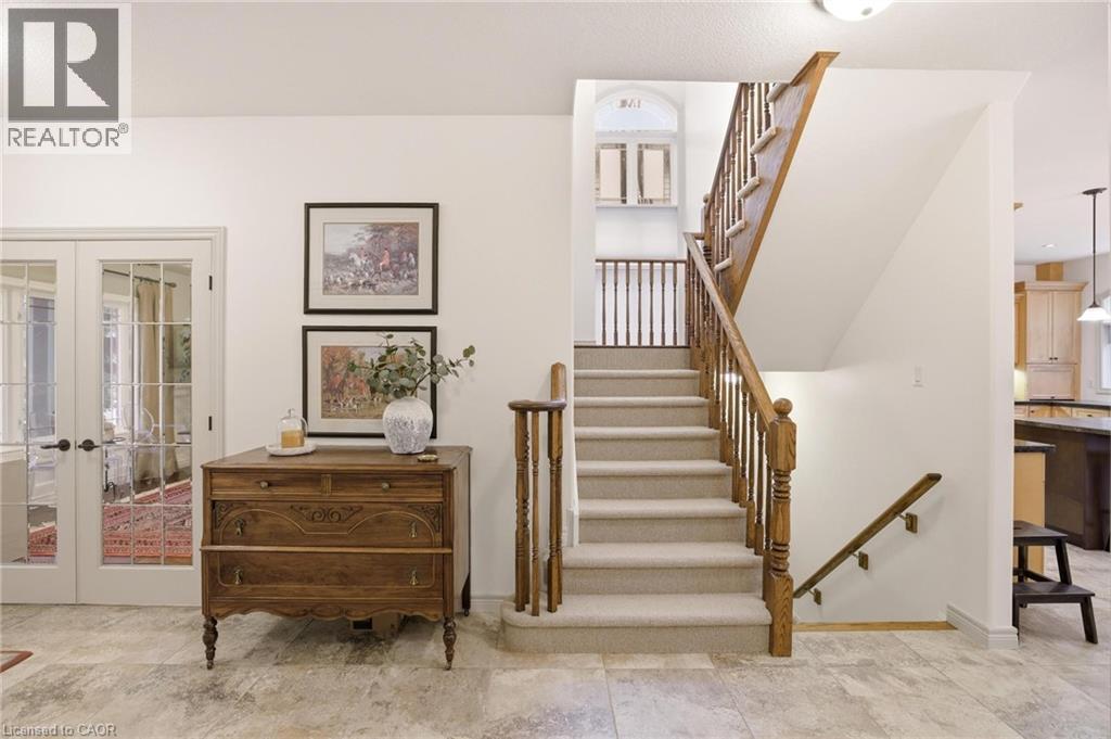 Carpeted staircase with wood handrails and balusters - 129 Magnificent Way, Binbrook, ON - Indoor Photo Showing Other Room