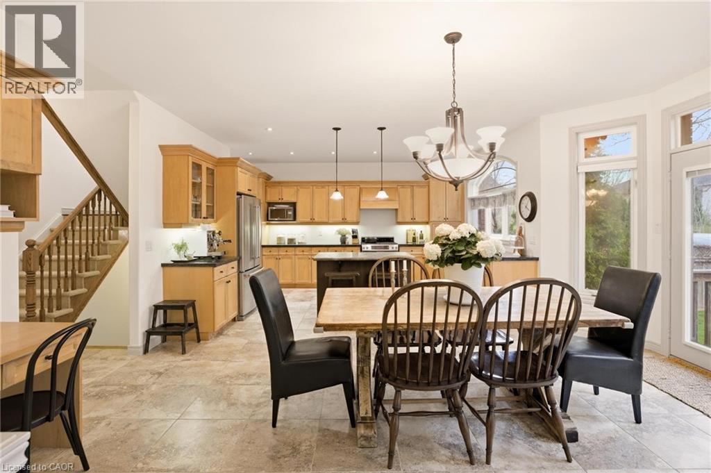 Kitchen and dining area featuring light wood-finish cabinetry, stainless steel appliances, and a central island - 129 Magnificent Way, Binbrook, ON - Indoor Photo Showing Dining Room
