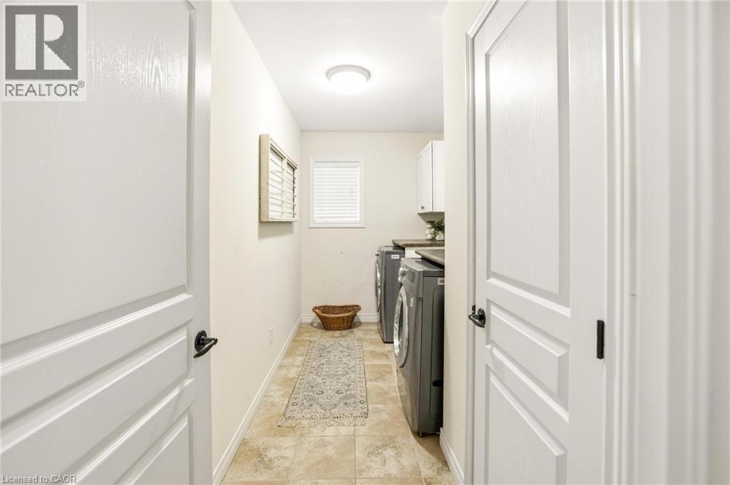 Dedicated laundry space featuring a window, overhead lighting, and neutral-toned wall paint - 129 Magnificent Way, Binbrook, ON - Indoor Photo Showing Other Room
