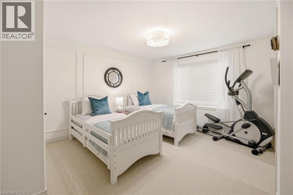 Carpeted room featuring a white ceiling light fixture, window with horizontal blinds, and wall panel molding - 129 Magnificent Way, Binbrook, ON - Indoor Photo Showing Bedroom