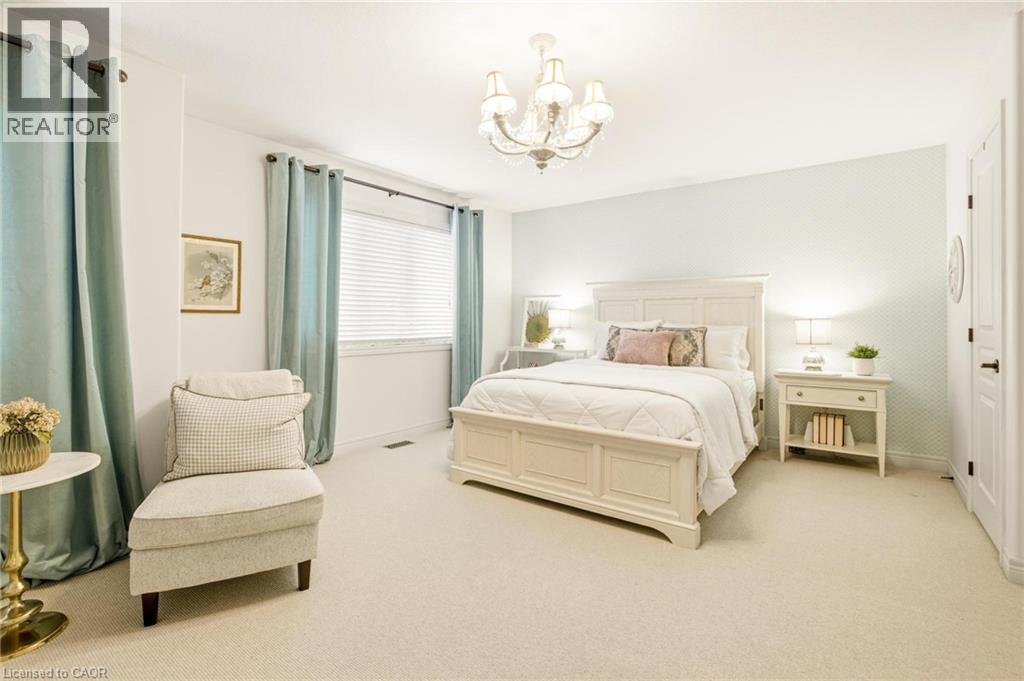 Bright room featuring light-colored carpeting, a multi-pane window with blinds, and a decorative chandelier - 129 Magnificent Way, Binbrook, ON - Indoor Photo Showing Bedroom