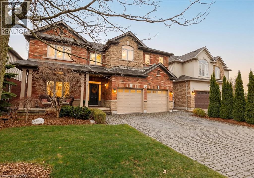 Two-story brick and stone facade residence featuring a covered front porch, two-car garage, and a paver stone driveway - 129 Magnificent Way, Binbrook, ON - Outdoor With Facade