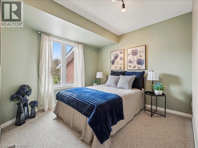 Carpeted room featuring a double window, light green walls, a white ceiling, and white baseboards - 245 Bishop Street S Unit# 4, Cambridge, ON - Indoor Photo Showing Bedroom
