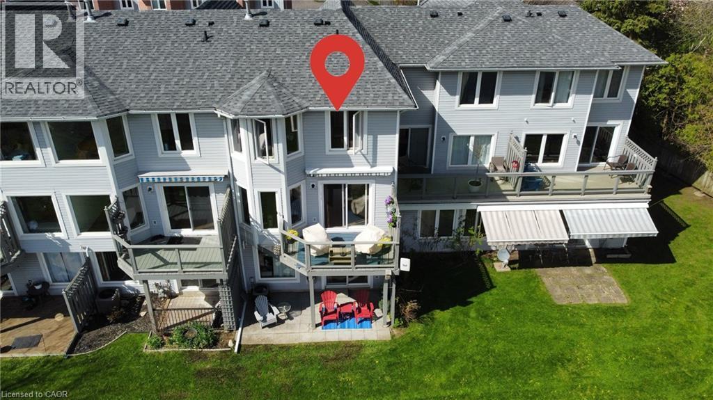 Rear exterior featuring multiple balconies, a ground-level patio, and a manicured lawn - 245 Bishop Street S Unit# 4, Cambridge, ON - Outdoor