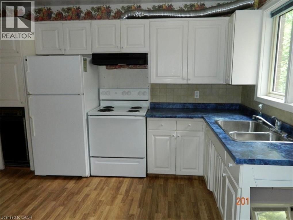 Kitchen featuring white cabinetry, blue countertops, a double basin stainless steel sink, and wood-finish flooring - 134 Greenbrier Drive, Waterloo, ON - Indoor Photo Showing Kitchen With Double Sink