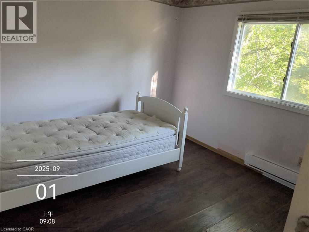 Room featuring wood-finish flooring, white walls, and a large window with white trim - 134 Greenbrier Drive, Waterloo, ON - Indoor Photo Showing Bedroom