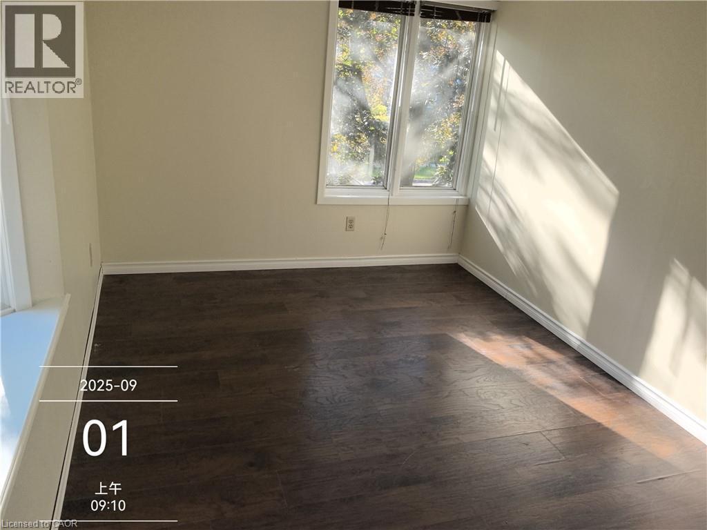 Room featuring wood-finish flooring, neutral wall paint, and white baseboards - 134 Greenbrier Drive, Waterloo, ON - Indoor Photo Showing Other Room