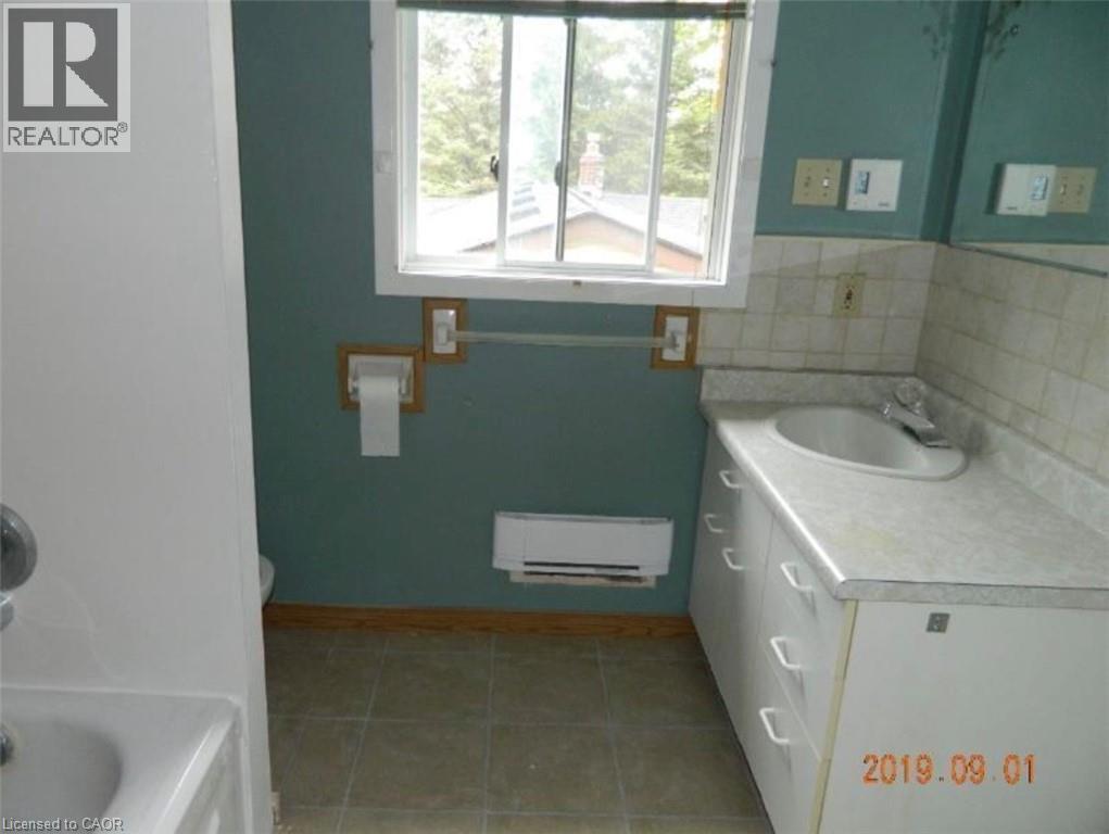 Bathroom featuring a vanity with an integrated sink, a tiled backsplash, and a window with natural light - 134 Greenbrier Drive, Waterloo, ON - Indoor Photo Showing Bathroom