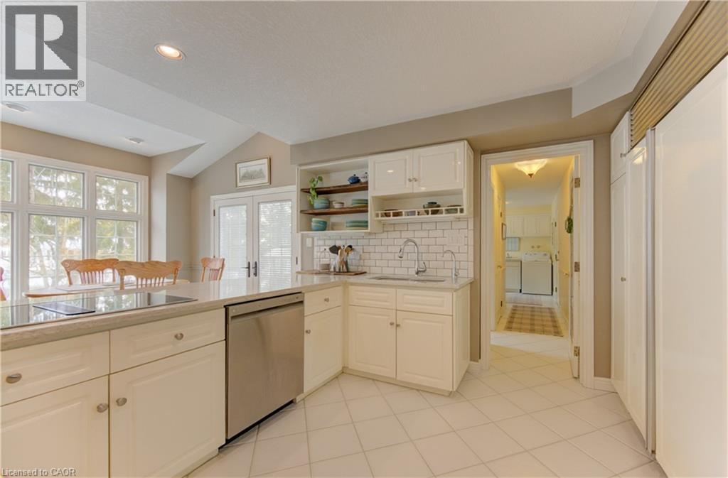 Kitchen featuring white cabinetry, a built-in cooktop, stainless steel dishwasher, and a light-toned countertop - 514 Colonial Drive, Waterloo, ON - Indoor Photo Showing Kitchen With Double Sink