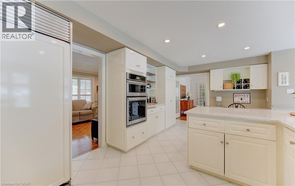 Kitchen featuring white cabinetry, light-toned tile flooring, recessed lighting, double wall ovens, and an integrated refrigerator - 514 Colonial Drive, Waterloo, ON - Indoor Photo Showing Kitchen