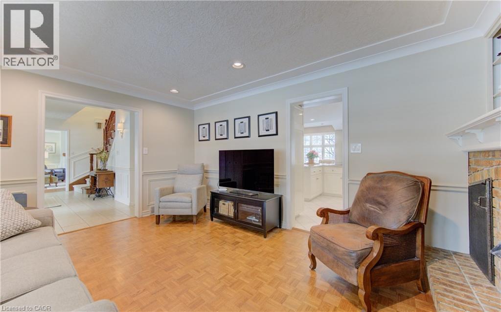Living area featuring parquet wood flooring and a brick fireplace - 514 Colonial Drive, Waterloo, ON - Indoor Photo Showing Living Room