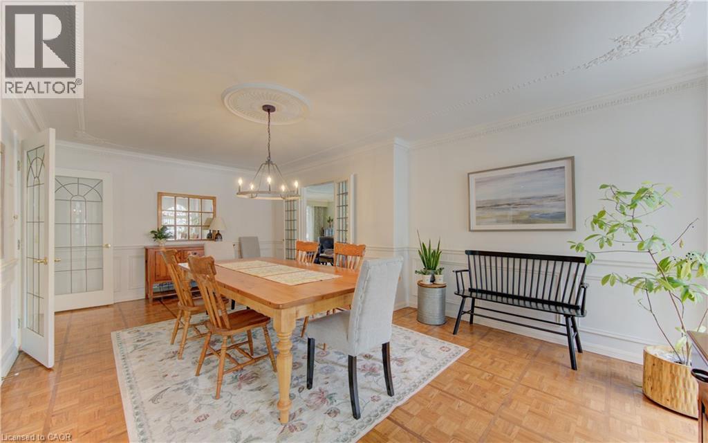 Spacious room featuring parquet wood-finish flooring, wainscoting, and crown molding - 514 Colonial Drive, Waterloo, ON - Indoor Photo Showing Dining Room