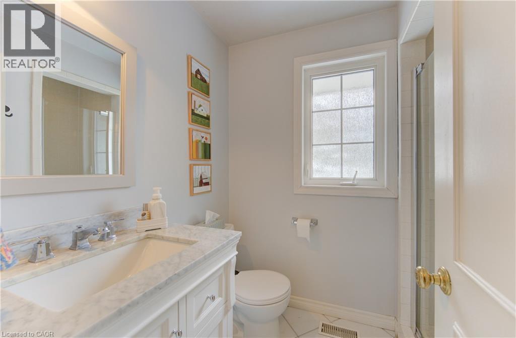 Bathroom vanity featuring a polished stone countertop and an undermount sink - 514 Colonial Drive, Waterloo, ON - Indoor Photo Showing Bathroom