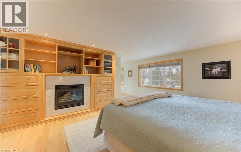 Custom built-in cabinetry with integrated fireplace, ample shelving, and drawer storage - 514 Colonial Drive, Waterloo, ON - Indoor Photo Showing Bedroom With Fireplace