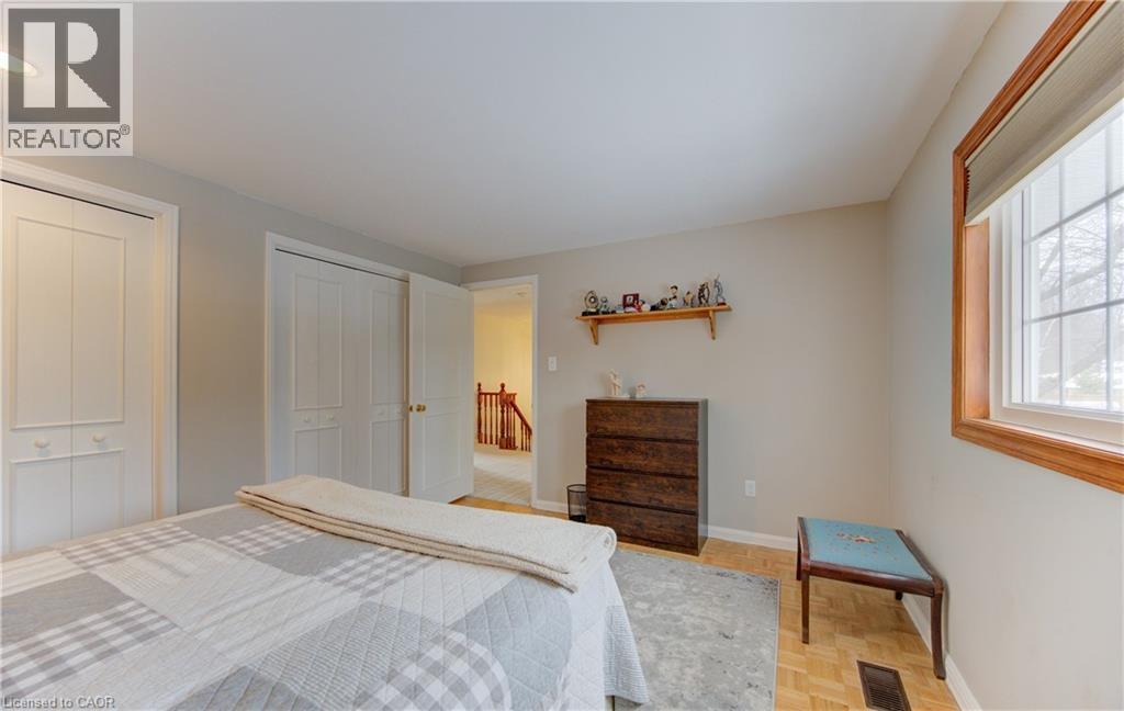 Bedroom featuring two bi-fold closet doors and wood-finish flooring - 514 Colonial Drive, Waterloo, ON - Indoor Photo Showing Bedroom