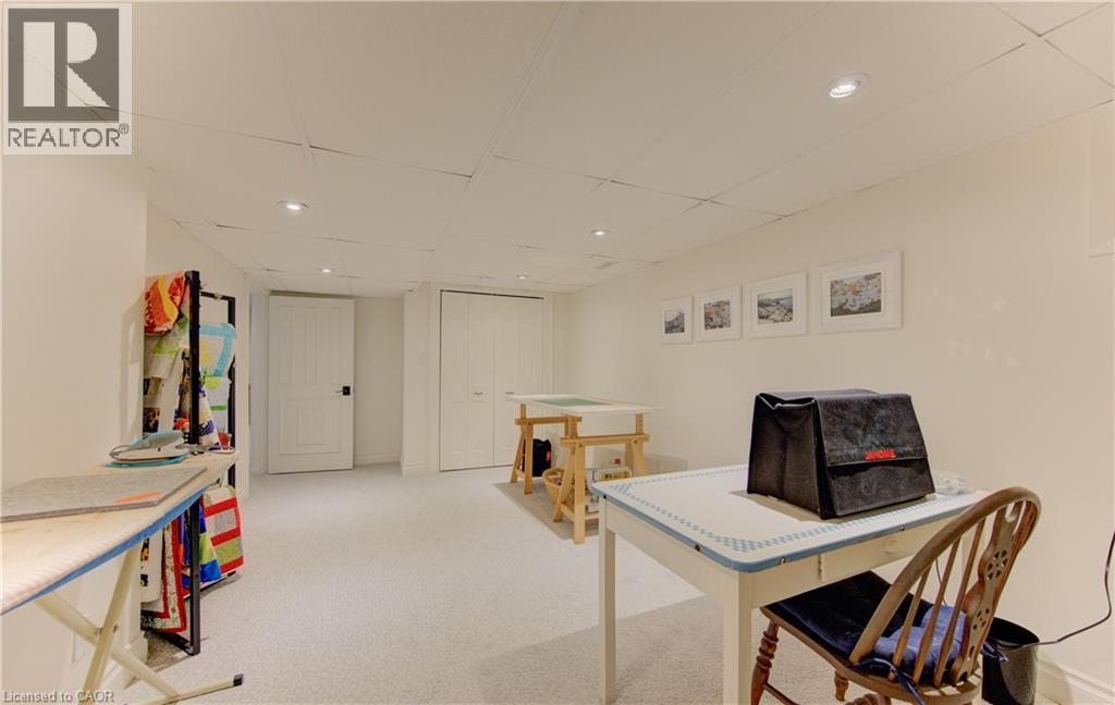 Finished lower level featuring recessed lighting, light-toned carpeting, two white paneled doors, and a drop ceiling - 514 Colonial Drive, Waterloo, ON - Indoor