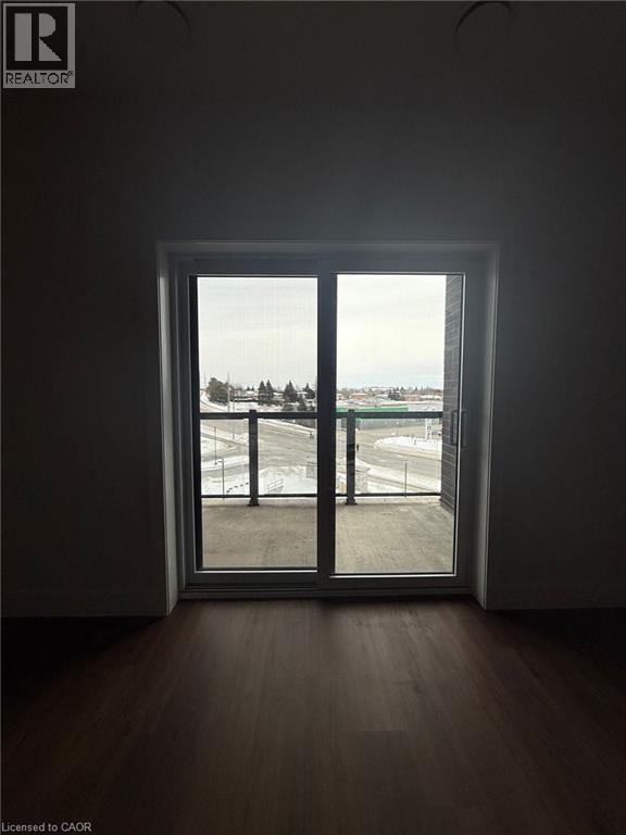 Empty room featuring dark wood finished floors - 1000 Lackner Place Unit# 401, Kitchener, ON - Indoor Photo Showing Other Room