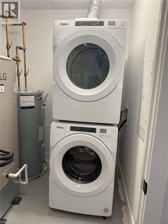 Laundry area with water heater, stacked washer / drying machine, and laundry area - 1000 Lackner Place Unit# 401, Kitchener, ON - Indoor Photo Showing Laundry Room