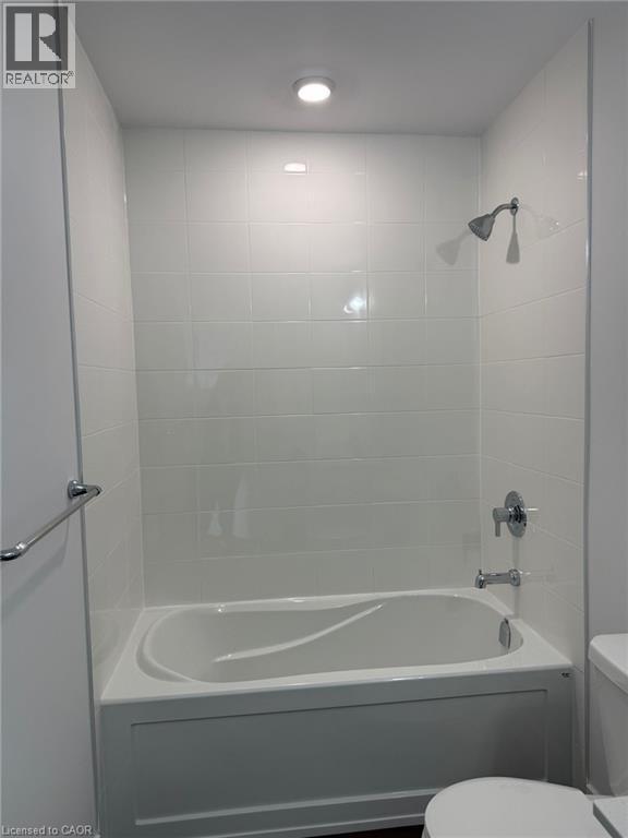 Bathroom featuring toilet and washtub / shower combination - 1000 Lackner Place Unit# 401, Kitchener, ON - Indoor Photo Showing Bathroom
