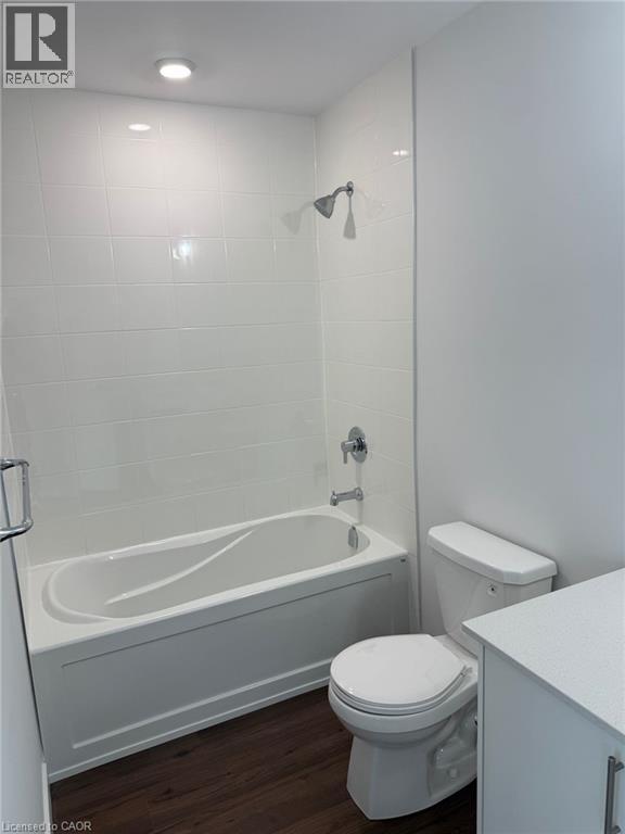 Full bath featuring toilet, wood finished floors, vanity, and shower / bath combination - 1000 Lackner Place Unit# 401, Kitchener, ON - Indoor Photo Showing Bathroom