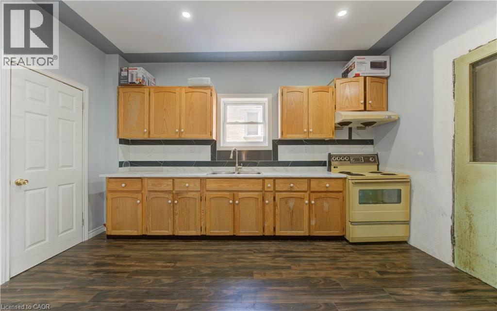 Kitchen with decorative backsplash, electric stove, light countertops, dark wood finished floors, and recessed lighting - 138 Courtland Avenue E, Kitchener, ON - Indoor Photo Showing Kitchen