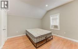 Bedroom featuring lofted ceiling, light wood-style floors, and recessed lighting -