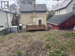 Back of property featuring a deck, a chimney, and an outdoor structure -