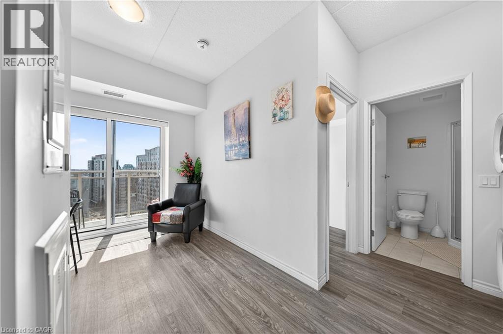 Living area featuring wood-finish flooring and a glass sliding door opening to a balcony - 246 Lester Street Unit# Ph-03, Waterloo, ON - Indoor