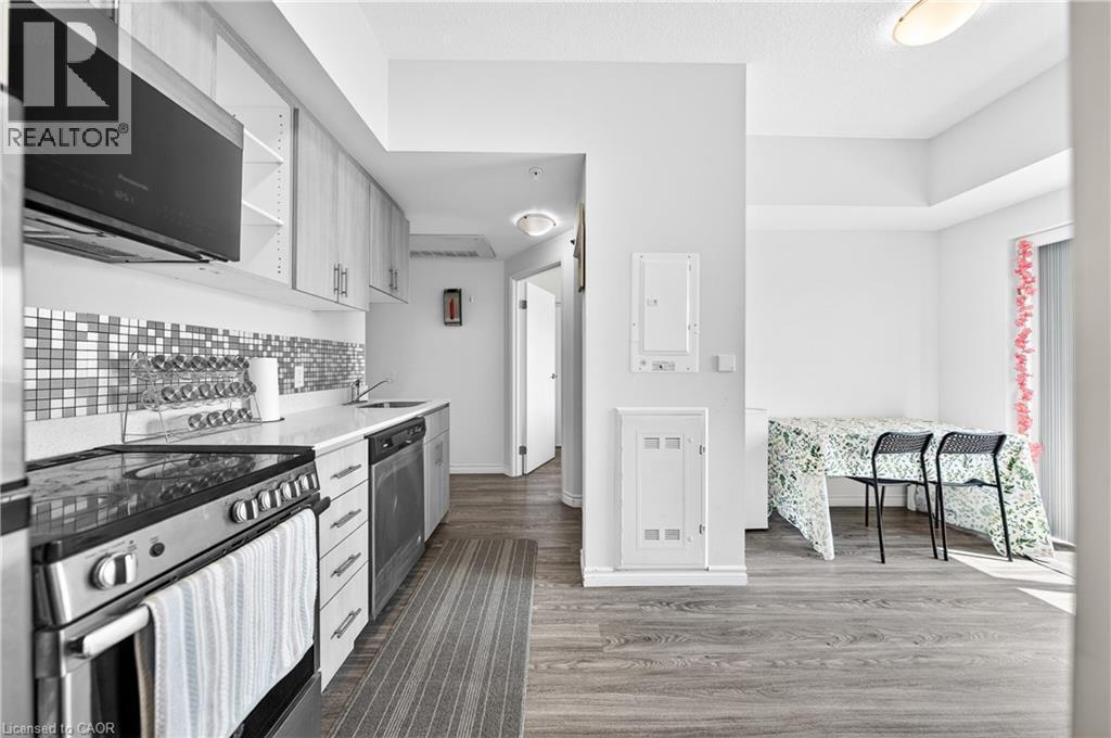 Modern kitchen featuring light wood-finish cabinetry, stainless steel appliances, a mosaic tile backsplash, and light countertops - 246 Lester Street Unit# Ph-03, Waterloo, ON - Indoor Photo Showing Kitchen