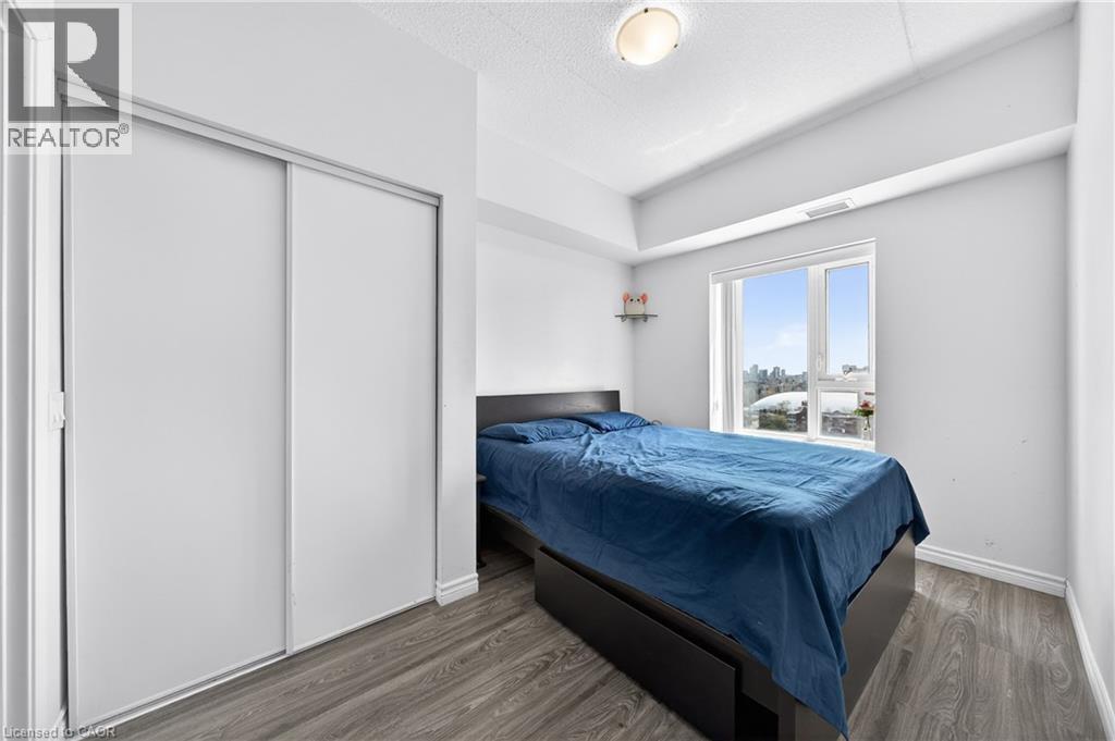 Room featuring light gray walls, wood-finish flooring, and white baseboards - 246 Lester Street Unit# Ph-03, Waterloo, ON - Indoor Photo Showing Bedroom