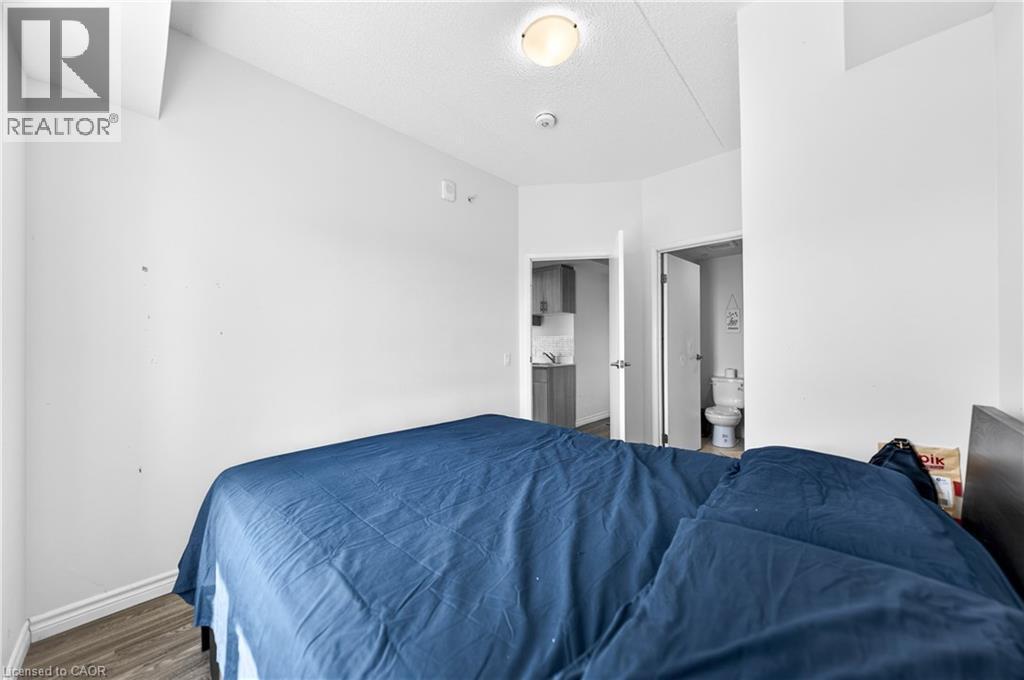 Interior space featuring wood-finish flooring, white walls, and a ceiling-mounted light fixture - 246 Lester Street Unit# Ph-03, Waterloo, ON - Indoor Photo Showing Bedroom