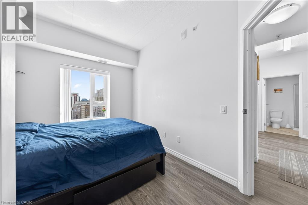 Bright interior space featuring a large window, light wood-finish flooring, and crisp white walls - 246 Lester Street Unit# Ph-03, Waterloo, ON - Indoor Photo Showing Bedroom