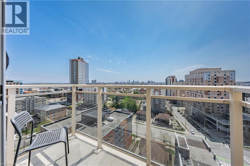 Balcony featuring a glass railing and concrete flooring, offering an expansive cityscape and distant water horizon - 246 Lester Street Unit# Ph-03, Waterloo, ON - Outdoor With Balcony With View
