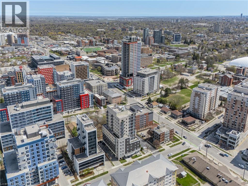 Urban landscape featuring a variety of multi-story buildings, extensive green spaces, and visible infrastructure elements - 246 Lester Street Unit# Ph-03, Waterloo, ON - Outdoor With View