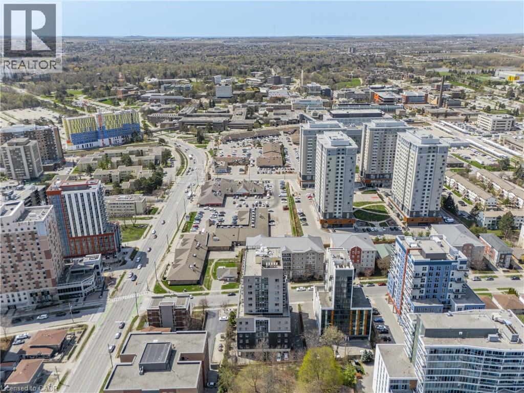 Aerial perspective showcasing a vibrant urban landscape with multiple high-rise residential buildings, commercial establishments, and a prominent roadway - 246 Lester Street Unit# Ph-03, Waterloo, ON - Outdoor With View
