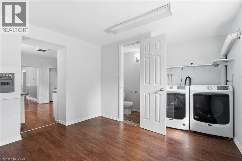 Dedicated laundry area featuring a washer and dryer, adjacent to a half bath - 137 Market Street, Hamilton, ON - Indoor Photo Showing Laundry Room