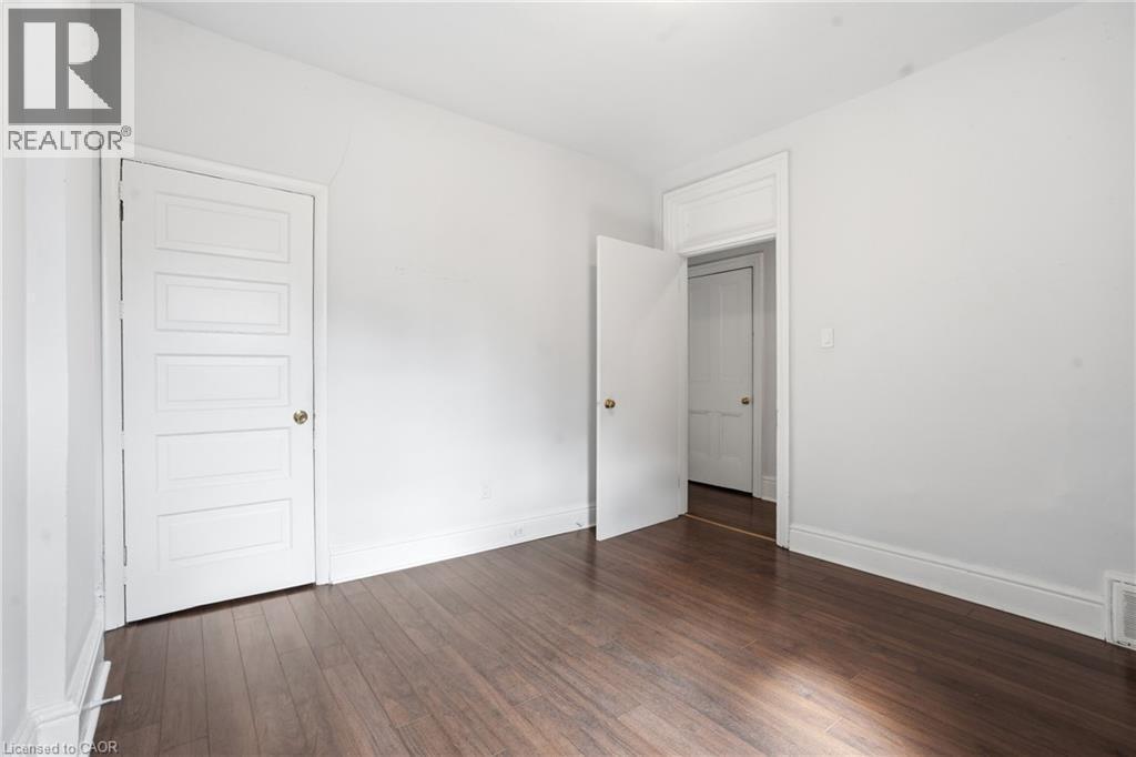 Interior room featuring dark wood-finish flooring, white walls, and white trim - 137 Market Street, Hamilton, ON - Indoor Photo Showing Other Room