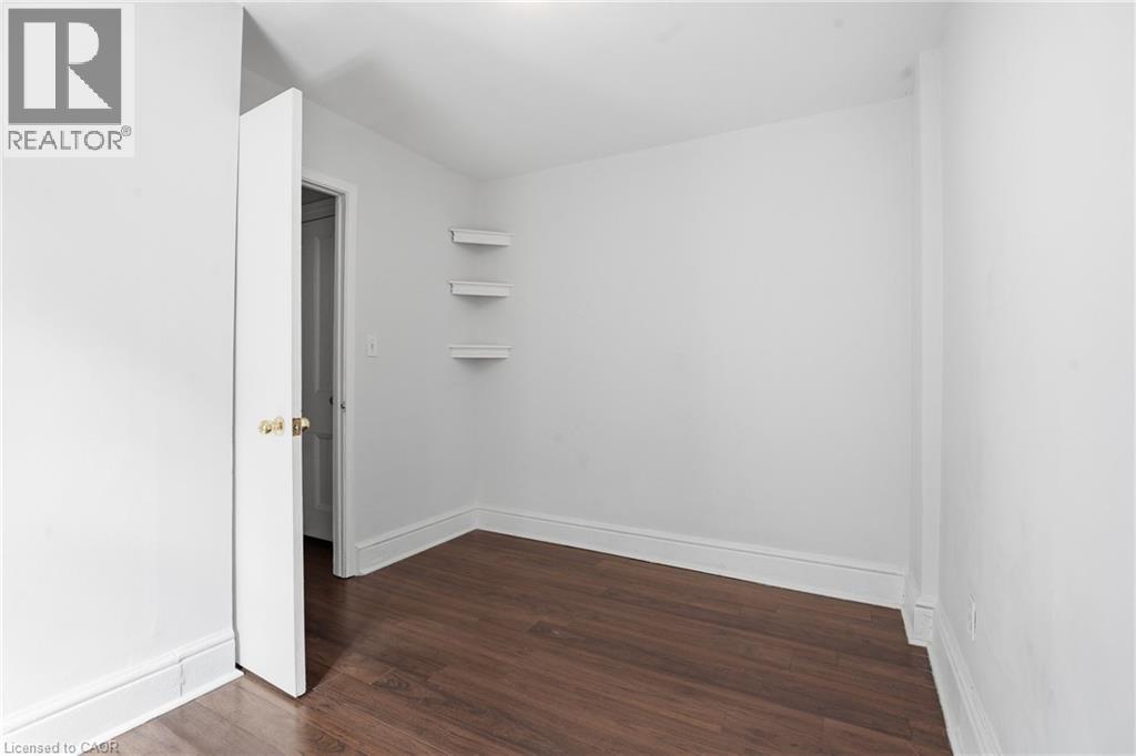 Room featuring wood-finish flooring, white walls, and white trim - 137 Market Street, Hamilton, ON - Indoor Photo Showing Other Room