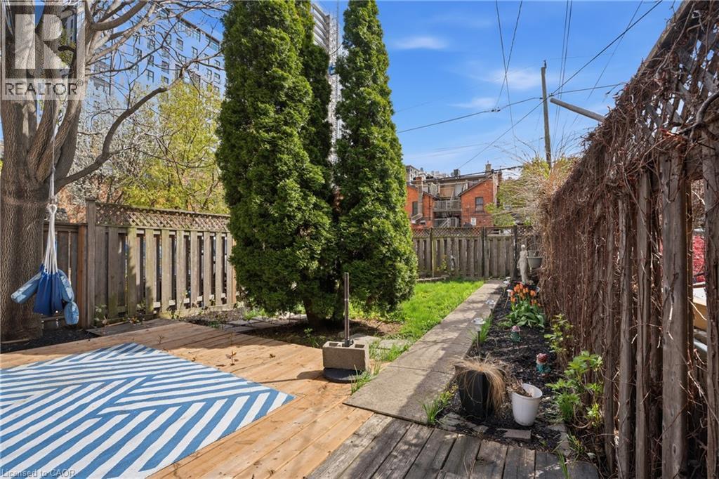 Expansive backyard featuring a wood deck, manicured lawn, and mature trees - 137 Market Street, Hamilton, ON - Outdoor
