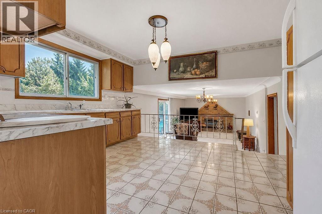 Kitchen featuring wood cabinetry, a window over the sink, and patterned tile flooring - 2344 Brinell Avenue, Burlington, ON - Indoor