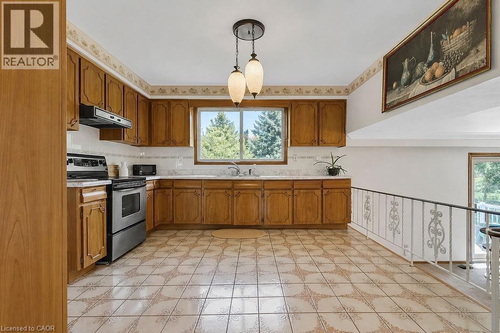Kitchen featuring wood cabinetry, white tile countertops, and a full suite of stainless-steel appliances - 2344 Brinell Avenue, Burlington, ON - Indoor Photo Showing Kitchen