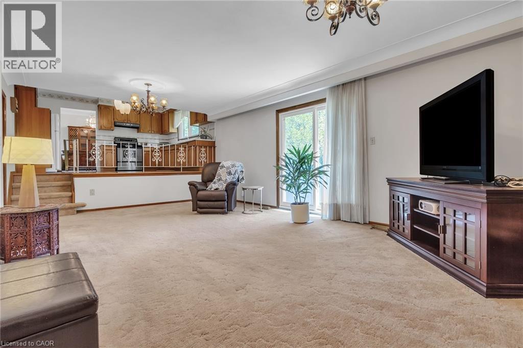 Open-concept living space featuring carpet flooring, a tiered ceiling, and a sliding glass door - 2344 Brinell Avenue, Burlington, ON - Indoor Photo Showing Living Room