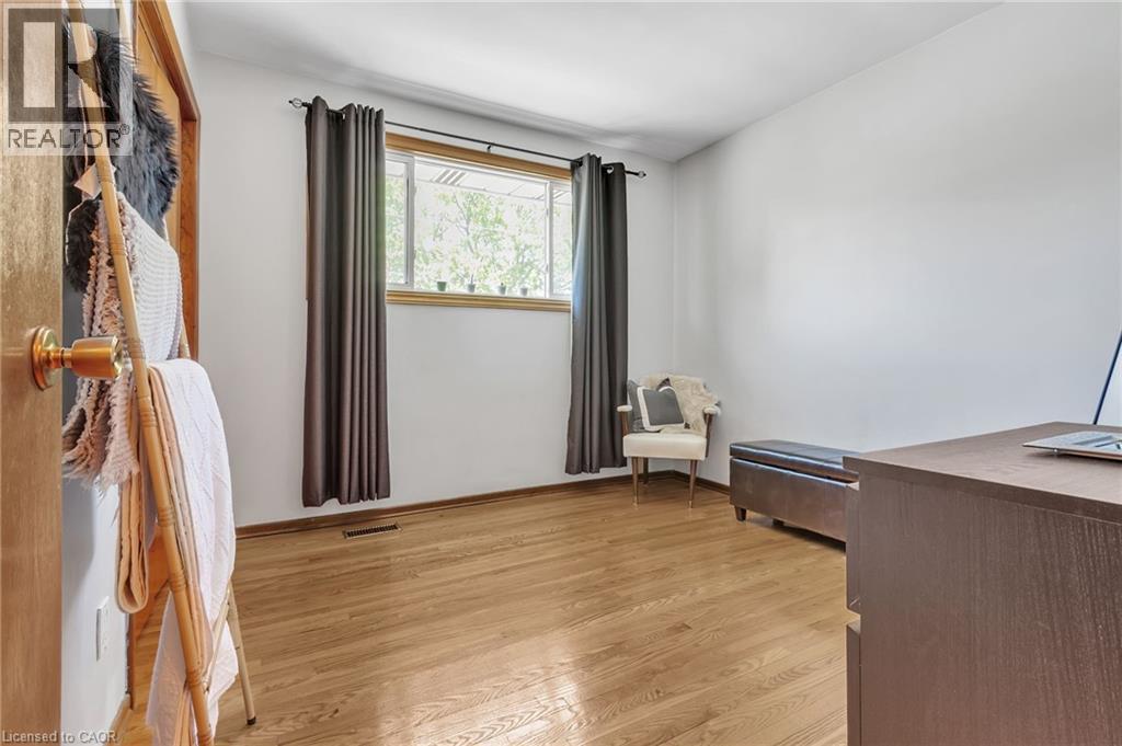 Room featuring wood-finish flooring, a window with natural wood trim, and white painted walls - 2344 Brinell Avenue, Burlington, ON - Indoor