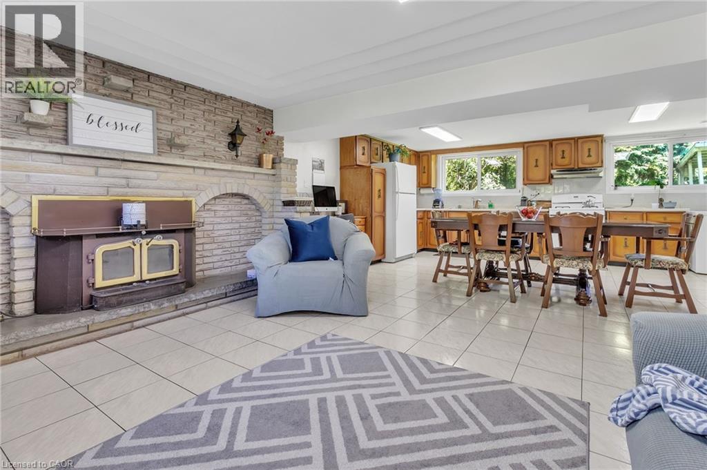 Expansive stone fireplace with a wood-burning insert and a tiled hearth - 2344 Brinell Avenue, Burlington, ON - Indoor With Fireplace