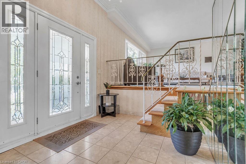 Entryway featuring an ornate double door with sidelights, decorative frosted glass, and light-toned tile flooring - 2344 Brinell Avenue, Burlington, ON - Indoor Photo Showing Other Room