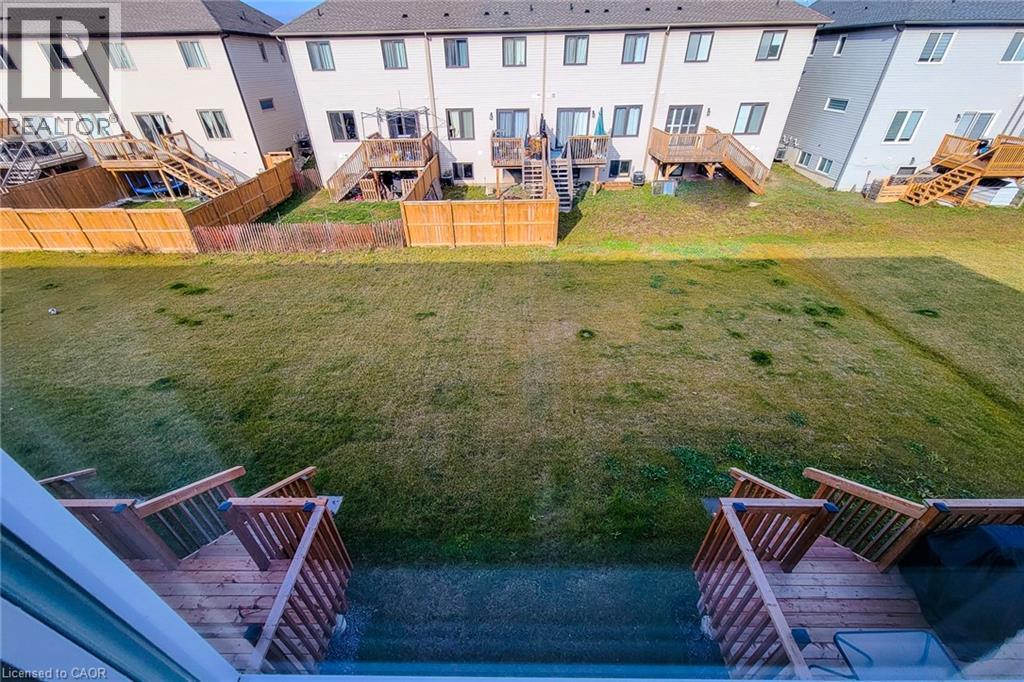 Expansive backyard featuring a large grass area, wood privacy fencing, and a multi-level wood deck with stairs - 111 Alicia Crescent, Thorold, ON